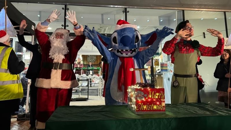 Santa outside the Town Hall with Stitch and an Elf