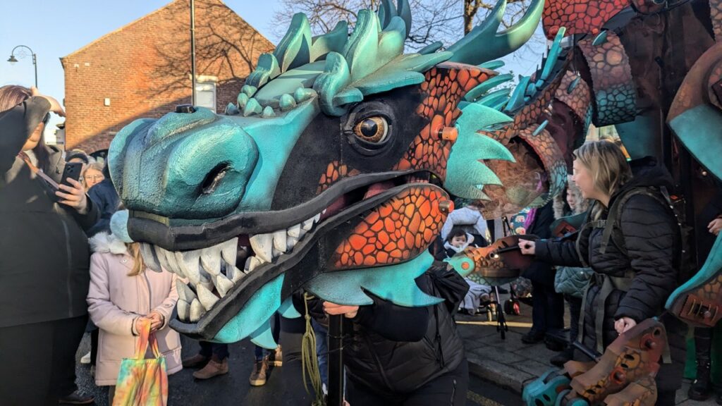 Brimstone the puppet dragon interacting with visitors on the steps of the Town Hall