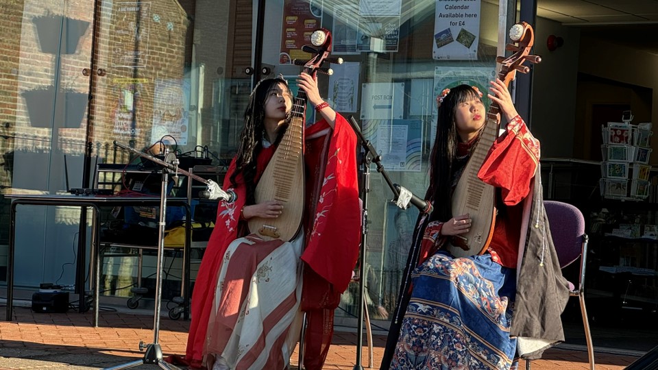 Yoyo and Lola Yau performing traditional Chinese folk music on their pipas on the steps of the Town Hall