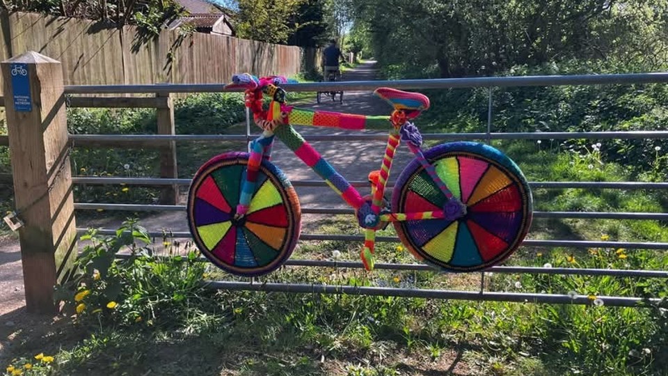 A yarn bombed bicycle in vibrant colours on the Biddulph Valley Way