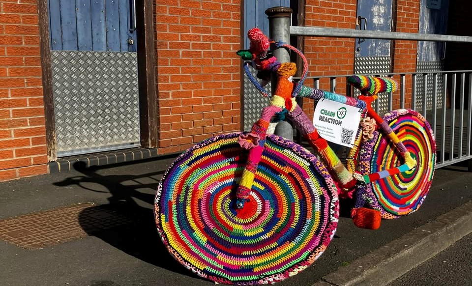 A yarn bombed bicycle in vibrant colours