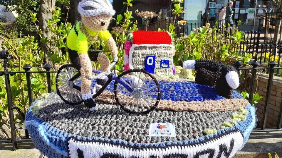The post box topper created by Biddulph Yarnbarms outside the Town Hall showing Councillor Nigel Yates cycling