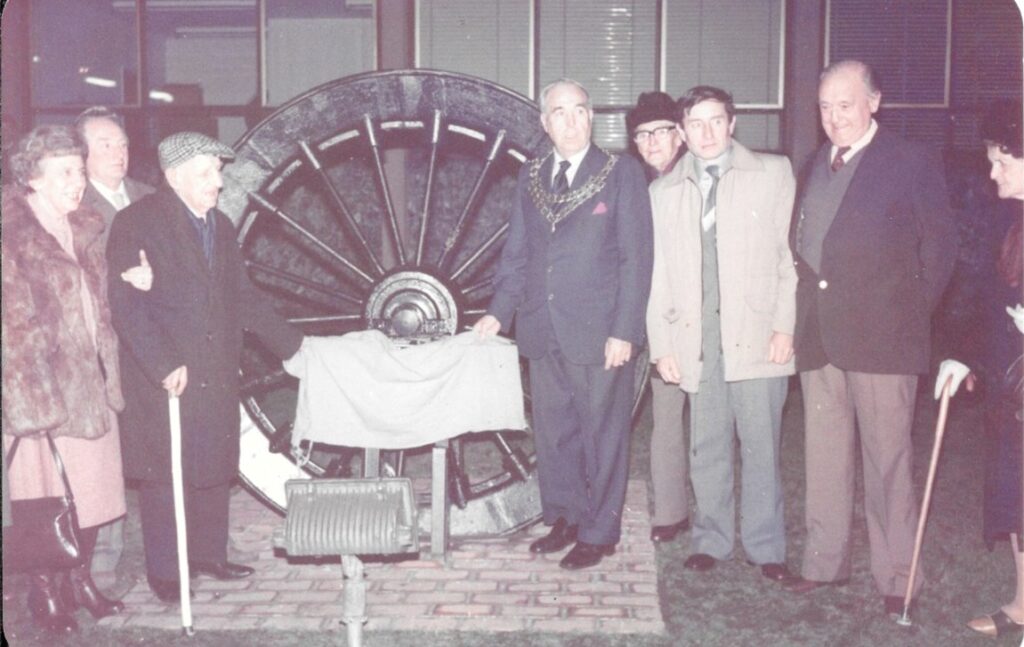 Eight attendees unveiling the mining wheel at the Town Hall in 1983. People listed in the wording.