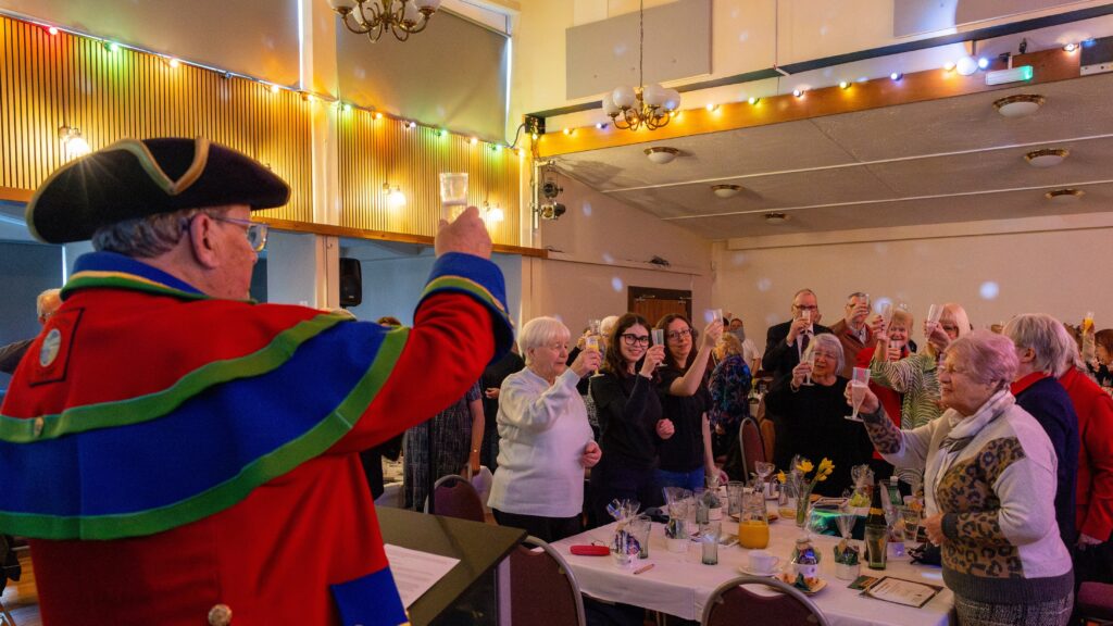 A group photo of attendees raising a toast.