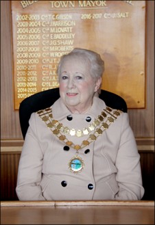A photo of Councillor Elaine Baddeley sitting in the Council Chamber wearing the Mayoral Chain of Office