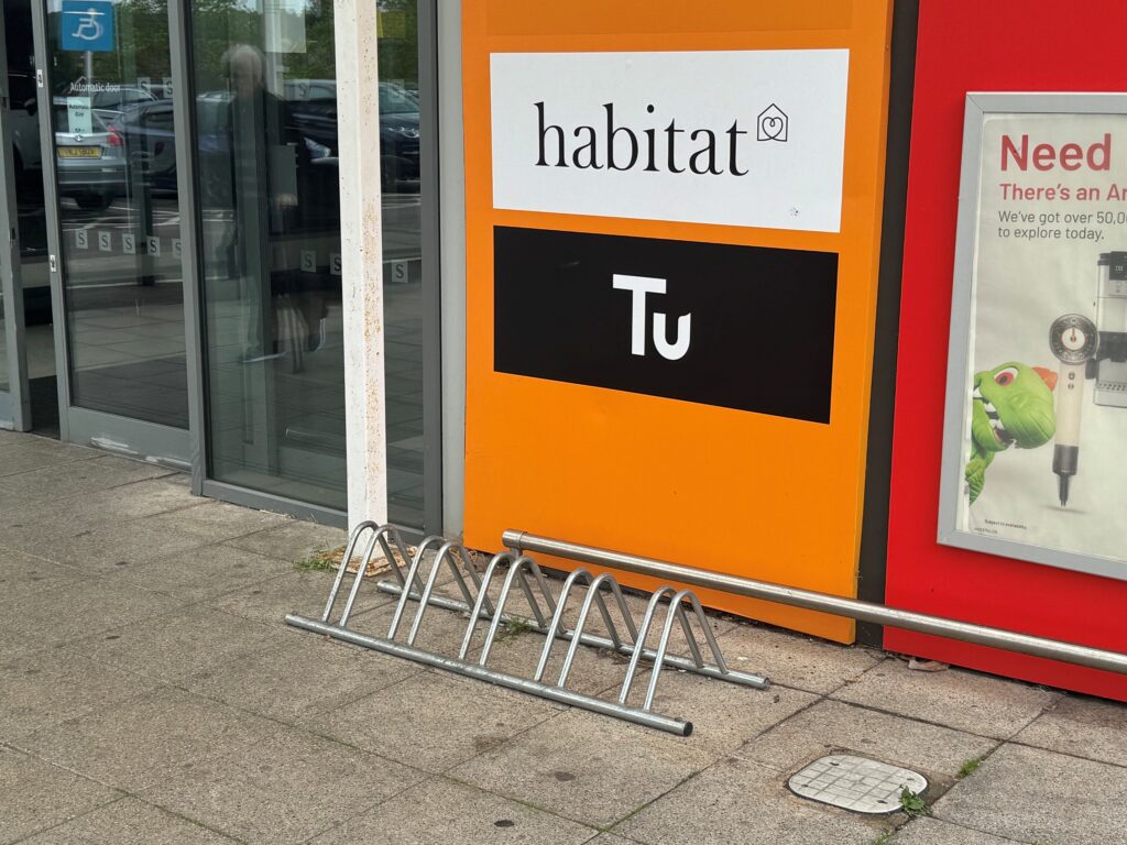 The cycle rack by the entrance to Sainsburys in front of Tu and habitat orange signage