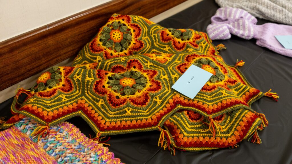 Entries in the Handicraft category, a crocheted shawl in vibrant red, green, orange and yellow