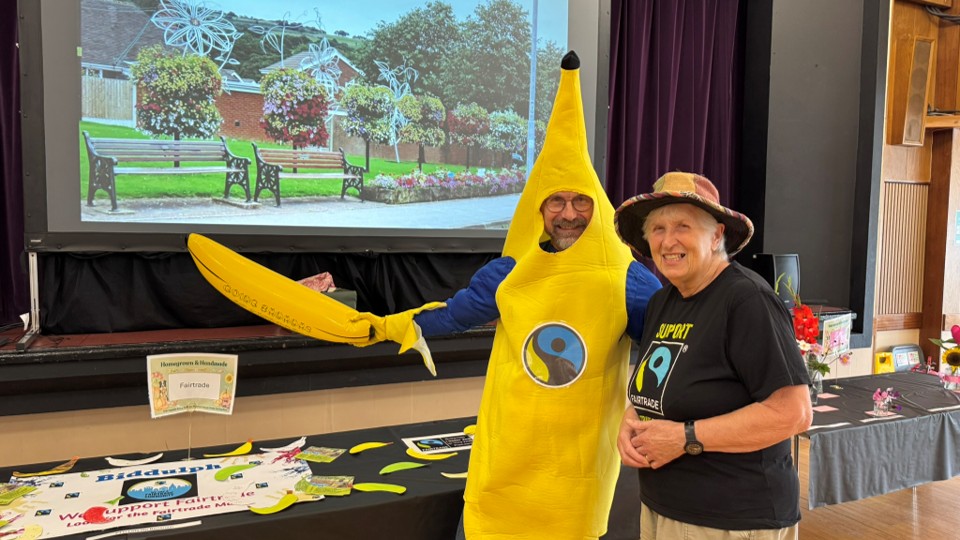 Councillor Jim Garvey dressed in a Fairtrade banana costume at the Fairtrade stall with Gillian from Fairtrade